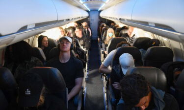 Airline passengers sit during an American Airlines flight from Los Angeles International Airport to Denver