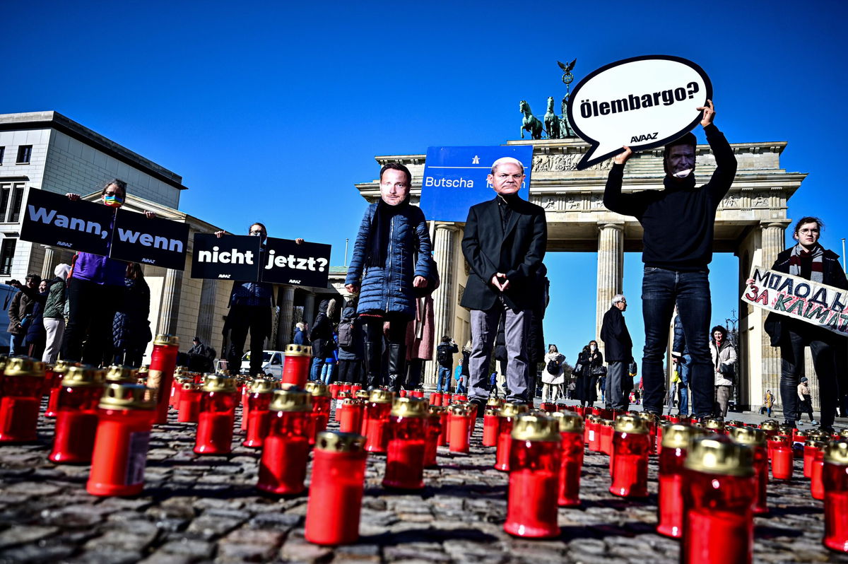 <i>Fabian Sommer/picture alliance/Getty Images</i><br/>Activists wearing masks with the likenesses of Chancellor Scholz (M)