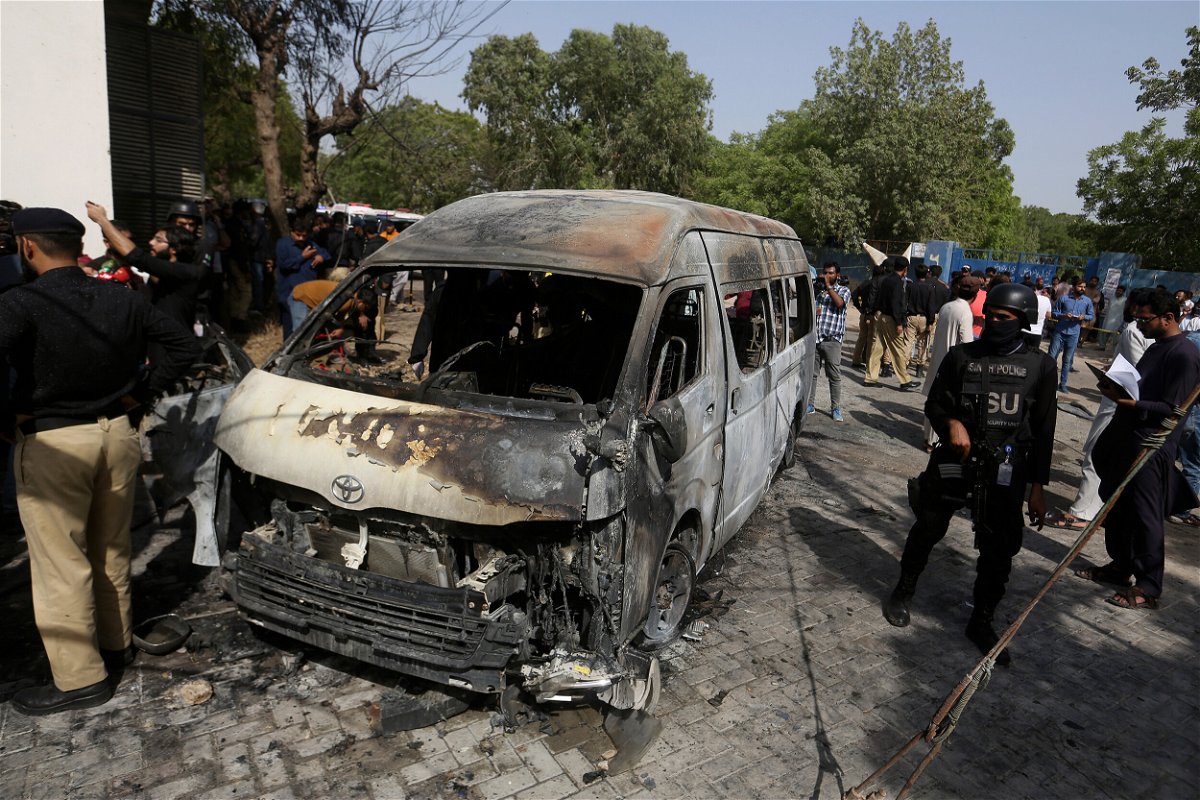 <i>Fareed Khan/AP</i><br/>Pakistani investigators examine the site of the explosion in Karachi