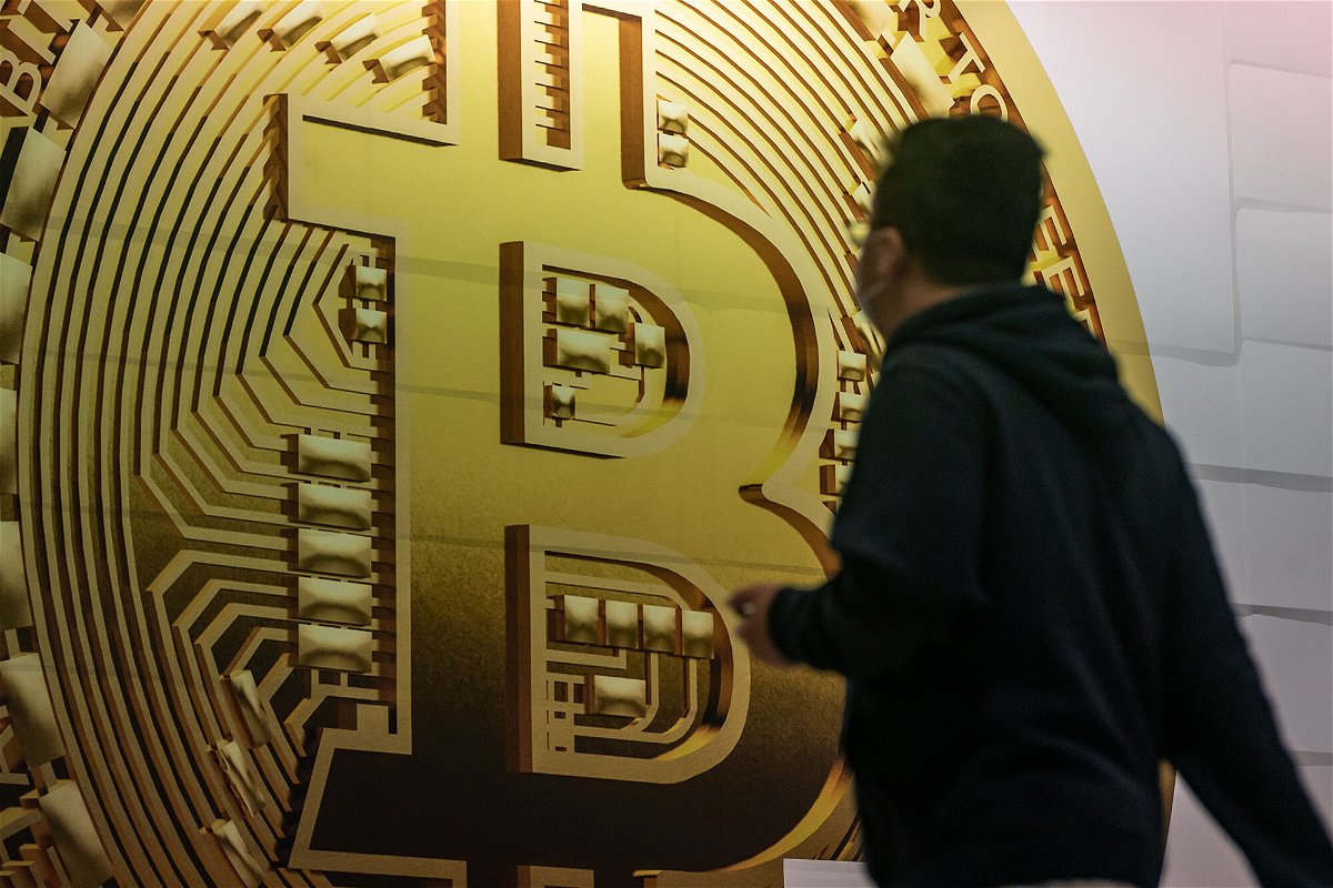 <i>Anthony Kwan/Getty Images</i><br/>Some 401(k)s will soon let you invest in crypto. Pedestrians are seen walking past an advertisement displaying a Bitcoin cryptocurrency token on February 15 in Hong Kong