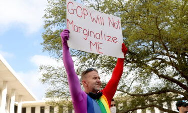 Tallahassee resident Glen Campbell holds up a sign at a rally at the Florida Capitol to protest the "Don't Say Gay" bill. Republicans build momentum as they drive anti-LGBTQ legislation nationwide.