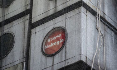A "Save Nakagin" sign is displayed in a window of Nakagin Capsule Tower in November 2021.