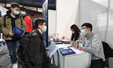 A student is seen at a job fair at the Beijing Institute of Technology in October 2021. A top Chinese regulator says the country's biggest tech companies have added nearly 80