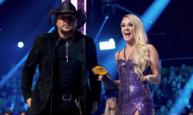 Jason Aldean and Carrie Underwood accept an award for collaborative video of the year onstage at the 2022 CMT Music Awards on April 11.