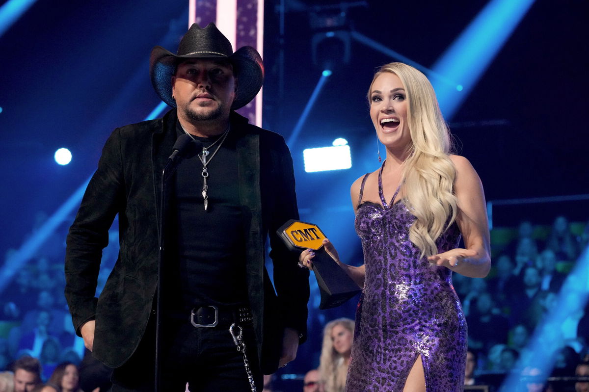 <i>Kevin Mazur/CMT/Getty Images</i><br/>Jason Aldean and Carrie Underwood accept an award for collaborative video of the year onstage at the 2022 CMT Music Awards on April 11.