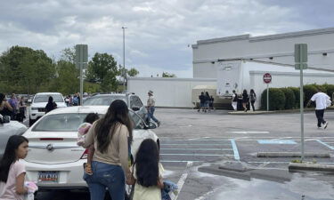 People walk through a parking lot at the Columbiana Centre mall in Columbia