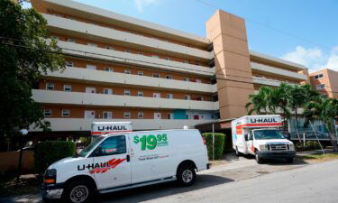 Moving vans and trucks are parked outside the Bayview 60 Homes apartment building in North Miami Beach