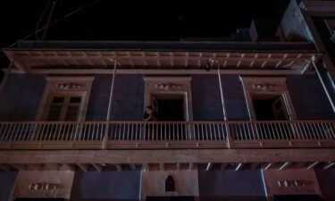 A man stands on a balcony in San Juan