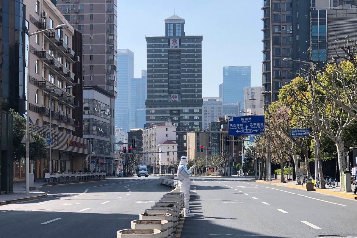 <i>Chen Si/AP</i><br/>A worker in protective overall stands in the middle of empty streets in a lockdown area in the Jingan district of western Shanghai