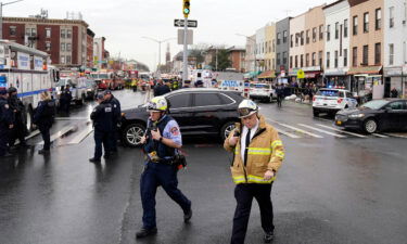 Emergency personnel gathers at a subway stop in Brooklyn on Tuesday. A gunman filled a rush-hour subway train with smoke and shot multiple people leaving wounded commuters bleeding on a platform as others ran screaming