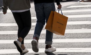 A pedestrian carries a Louis Vuitton shopping bag in San Francisco in September 2021. Higher prices and geopolitical concerns may soon slow demands for luxury goods.