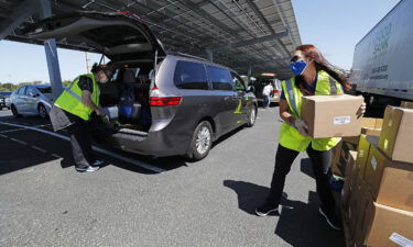 Volunteers and members of the Food Bank of Contra Costa and Solano counties help distribute food to people in need