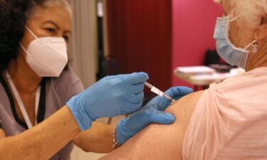 Registered Nurse Orlyn Grace (L) administers a COVID-19 booster vaccination to Jeanie Merriman (R) at a COVID-19 vaccination clinic on April 06 in San Rafael