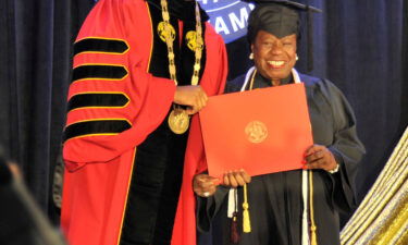 Mae Beale receives her diploma during a University of Maryland Global Campus commencement ceremony from UMGC President Gregory Fowler.