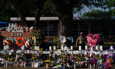 Flowers and candles are seen around crosses on May 28