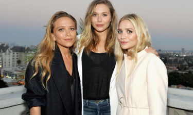 Elizabeth Olsen (center) says she was spoiled by sisters Mary-Kate and Ashley Olsen.