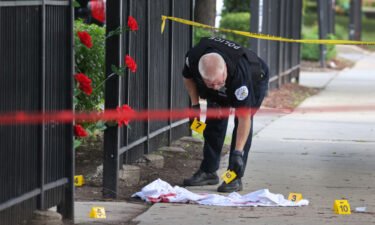 Police investigate a crime scene where three people were shot at the Wentworth Gardens housing complex in the Bridgeport neighborhood on June 23