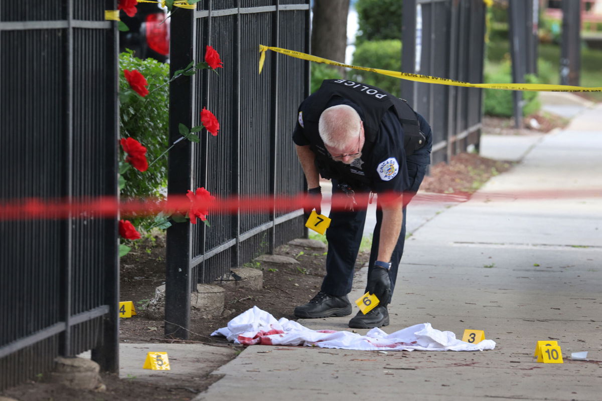 <i>Scott Olson/Getty Images</i><br/>Police investigate a crime scene where three people were shot at the Wentworth Gardens housing complex in the Bridgeport neighborhood on June 23