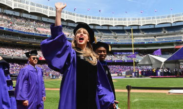 Taylor Swift waves at graduating students during New York University's commencement ceremony for the class of 2022.