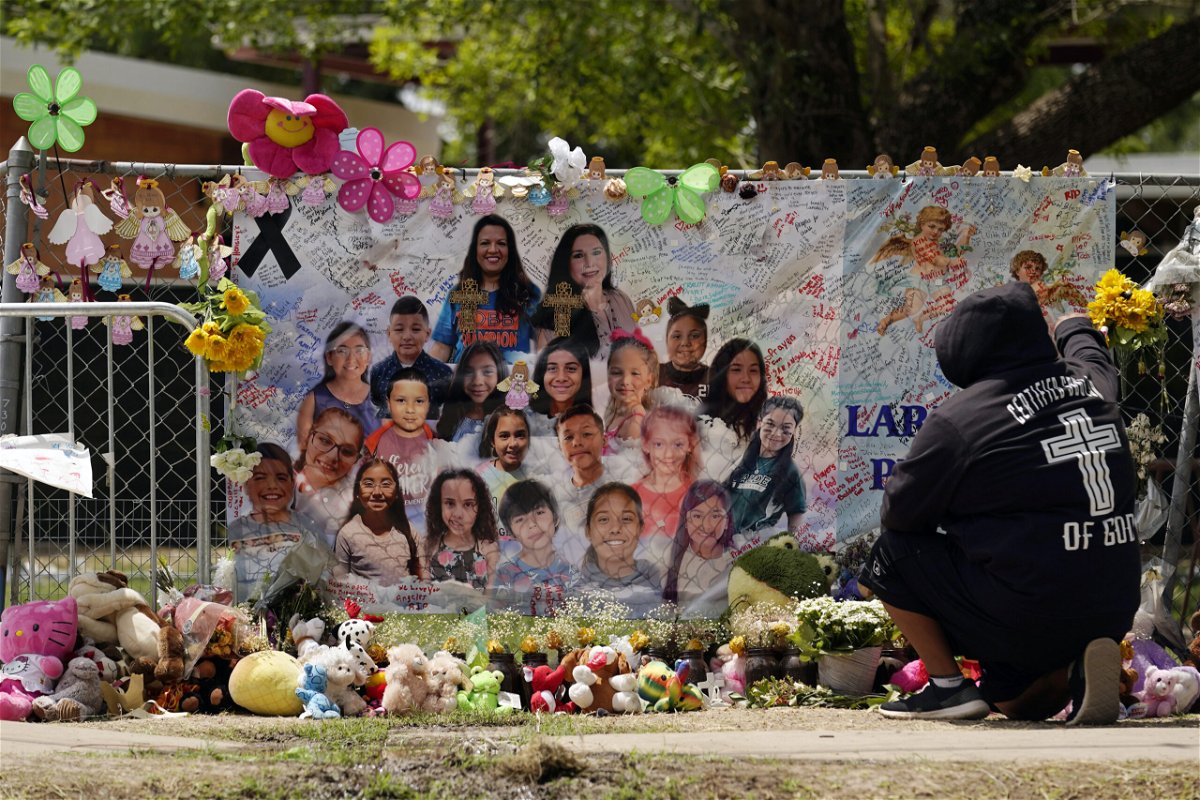 FILE - A mourner stops to pay his respects at a memorial at Robb Elementary School, created to honor the victims killed in the recent school shooting, June 9, 2022, in Uvalde, Texas. Two teachers and 19 students were killed in the mass shooting. Law enforcement authorities had enough officers on the scene of the Uvalde school massacre to have stopped the gunman three minutes after he entered the building, the Texas public safety chief testified Tuesday, June 21 pronouncing the police response an “abject failure.”
