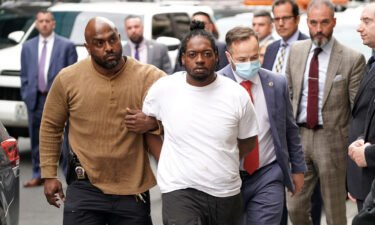 Andrew Abdullah is escorted into the 5th Precinct on Tuesday