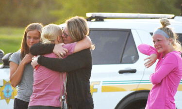 People console each other after a shooting outside Cornerstone Church in Ames