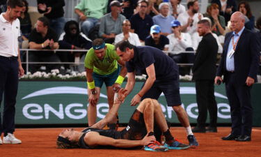 Alexander Zverev of Germany receives medical attention as Rafael Nadal of Spain looks on Friday in the men's semifinal match at the French Open.