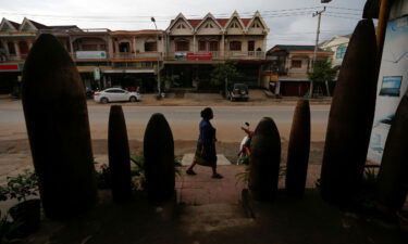 How a new library sheds light on the US 'secret war' in Laos. A woman is seen walking past a restaurant littered with unexploded bombs dropped by US Air Force planes during the Vietnam War