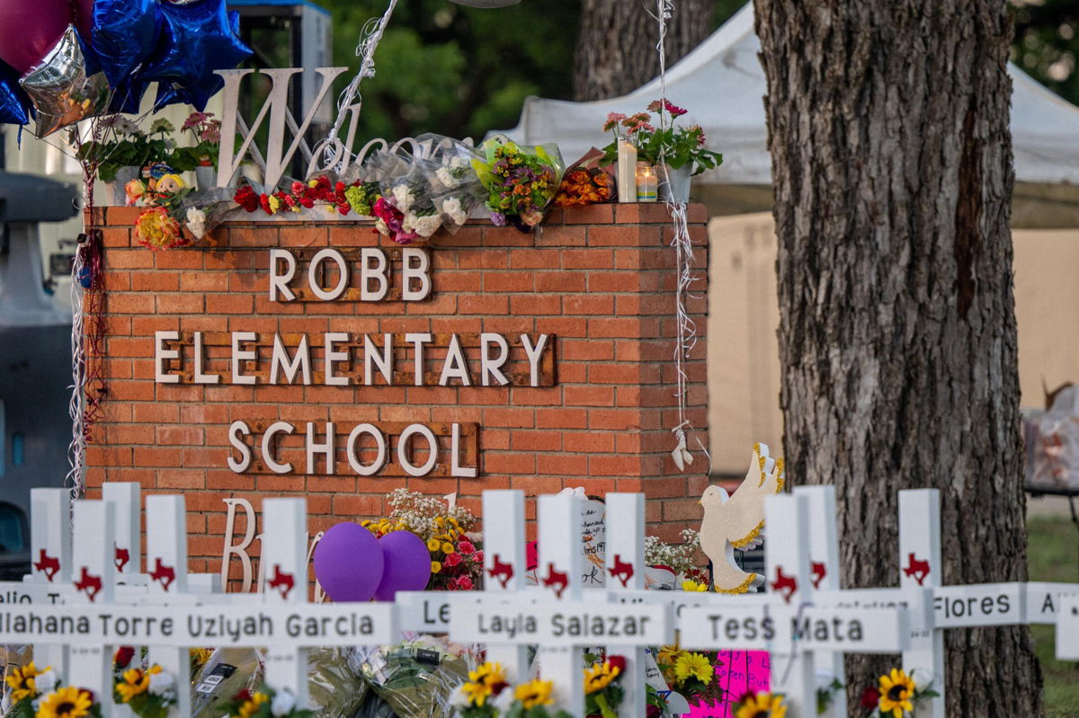 <i>Brandon Bell/Getty Images</i><br/>A memorial is seen surrounding the Robb Elementary School sign  on May 26