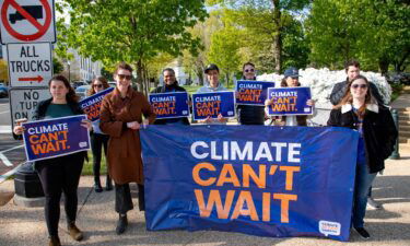 Activists with Climate Can't Wait hold a climate investment visibility demonstration on Capitol Hill as people head to work near Senate office buildings on April 28.