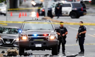 Police officers gather at the scene of a shootout in Saanich