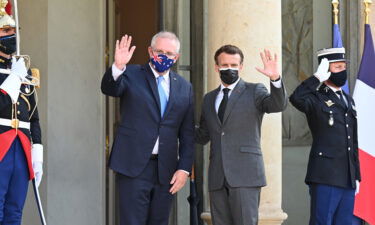 French President Emmanuel Macron (R) and Australian Prime Minister Scott Morrison (L) pose before dinner at the Elysee Palace in Paris