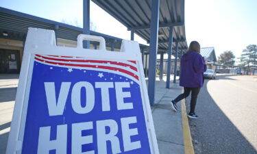 A person walks past a sign during a runoff election for Louisiana governor at a polling station at Quitman High School on November 16
