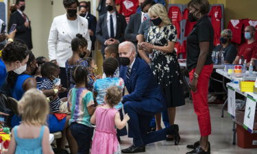 US President Joe Biden speaks with children while visiting a Covid-19 vaccination clinic hosted by the District of Columbia's Department of Health in Washington