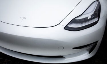 A logo is displayed on a Tesla Inc. electric vehicle charging at the Tesla Supercharger station in Fremont