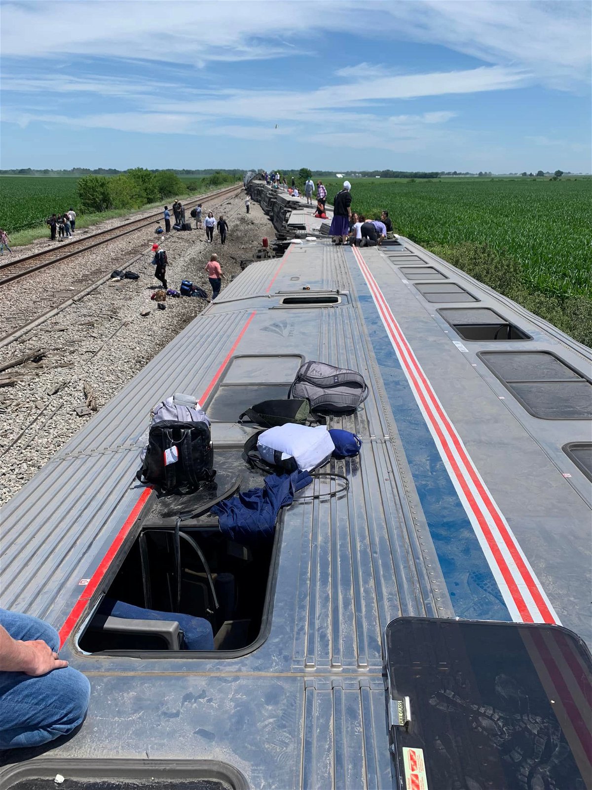 People leave Amtrak train cars after a derailment in Chariton County on Monday, June 27, 2022.