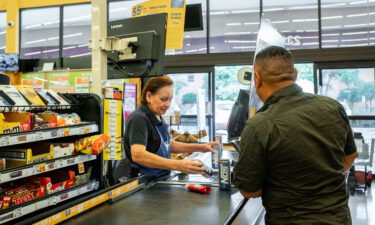 A customer is rung up by a cashier in a Kroger grocery store on July 15