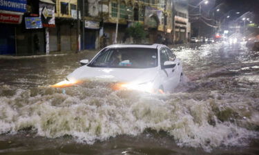 A vehicle drives along a flooded street following heavy rains during the monsoon season in Karachi