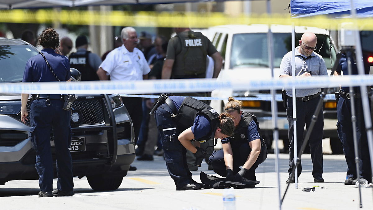 <i>Tammy Ljungblad/The Kansas City Star/AP</i><br/>Law enforcement officers look over the protective vest that North Kansas City Police Officer Daniel Vasquez was wearing when he was fatally shot during a traffic stop