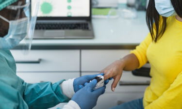 A medical worker examines a female patient with an oximeter device during the coronavirus outbreak.