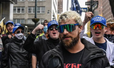 Far right livestreamer Baked Alaska (C) is cheered on by people associated with the far-right group America First in front of Pfizer world headquarters on November 13