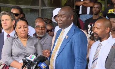 Attorney Ben Crump surrounded by the family of Robert Adams