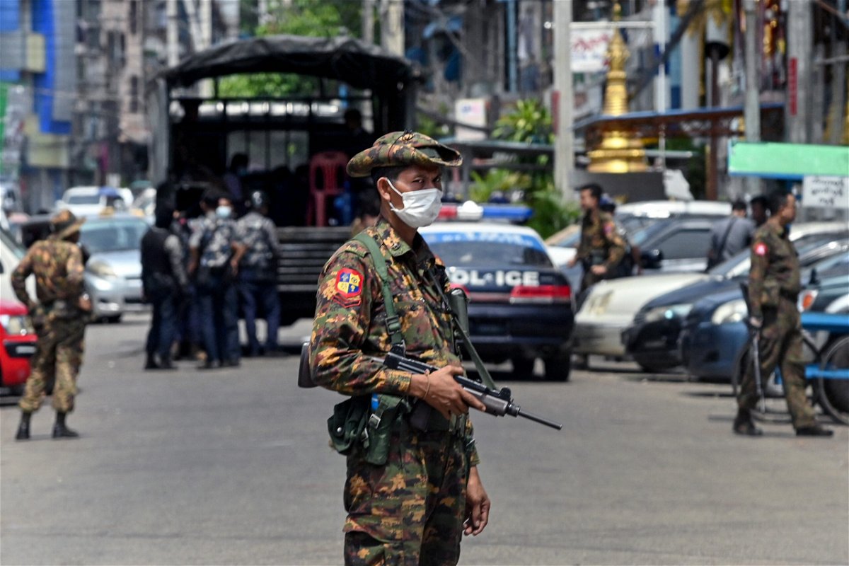 <i>STR/AFP/Getty Images</i><br/>A soldier stands guard along a road as security forces search for protesters in Yangon.