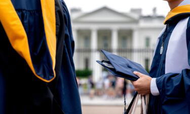 Students from George Washington University wear their graduation gowns outside of the White House in Washington