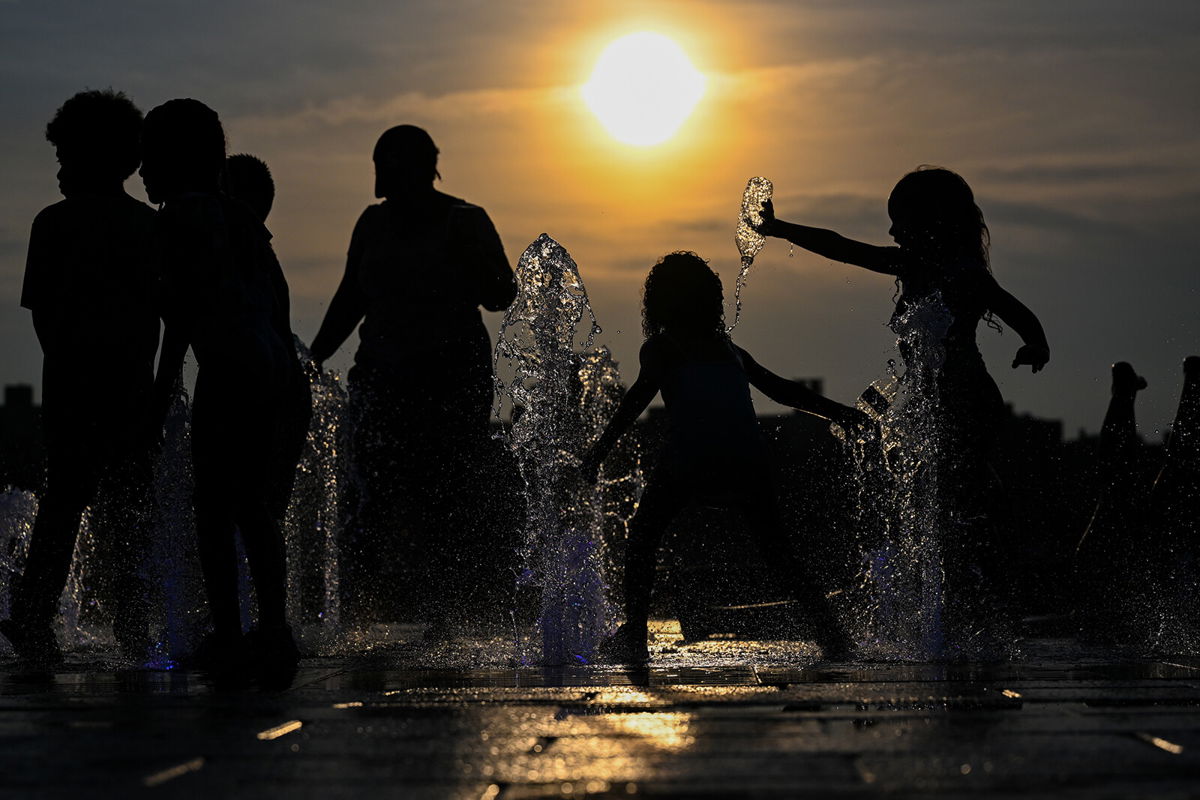 <i>Alexi Rosenfeld/Getty Images</i><br/>Children cool off by playing in a fountain in Domino Park