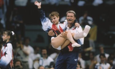 Kerri Strug of the United States is carried by coach Bela Karolyi during the team competition of the Women's Gymnastics event of the 1996 Summer Olympic Games held on July 23