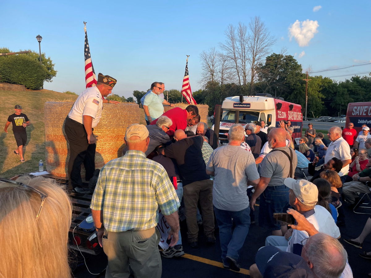 <i>Ian Winner/Reuters</i><br/>A group of people attending Rep. Lee Zeldin's speech gather around an alleged attacker in Fairport