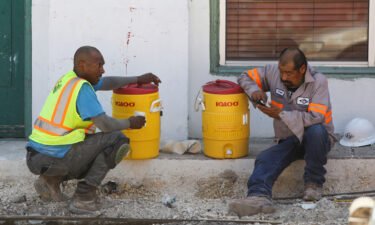 Construction workers Anthony Harris and Angel Gonzalez take a water break during an excessive heat warning in San Antonio