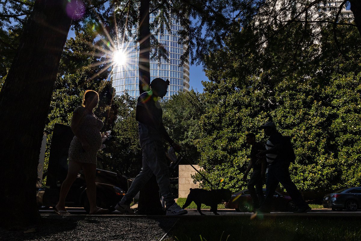 <i>Shelby Tauber/Bloomberg/Getty Images</i><br/>Pedestrians walk along a street during a heatwave in Dallas