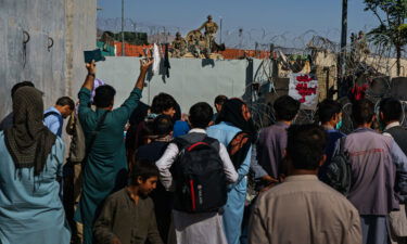 Afghans try to talk to American soldiers to ask to be let into the East Gate of the Airport in Kabul on August 25
